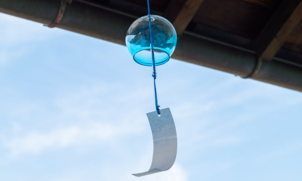 Japanische Furin-Windspiele bei einem Sommerfest — traditionelle japanische Windglocken mit bunten Tanzaku-Papierstreifen