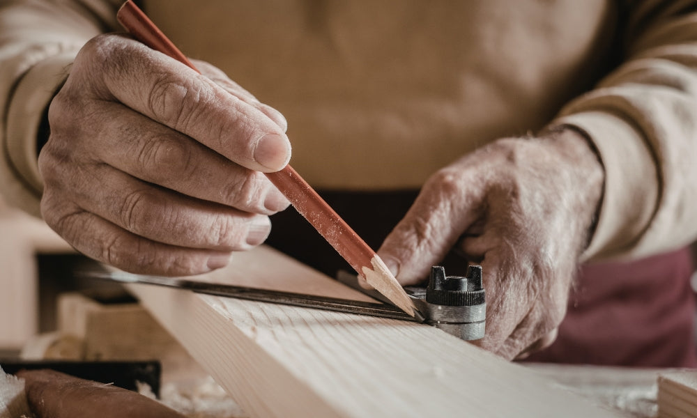 Hände eines japanischen Zimmerers beim Anreißen von Holz — traditionelle japanische Zimmerei und Holzverbindungstechnik