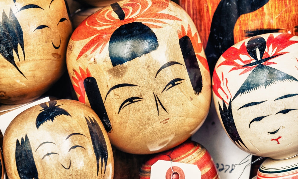 Traditionelle japanische Kokeshi-Puppen — Nahaufnahme handbemalter Holzköpfe aus Tōhoku, mit regionalen Mustern