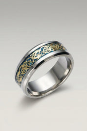 Ring 'Ringshine' in Blau — flacher Stahlring mit Mittelband, in das ein fadenfeiner Drache eingelegt ist, Produktfoto vor hellgrauem Hintergrund