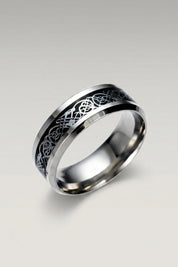 Ring 'Ringshine' in Schwarz — flacher Stahlring mit Mittelband, in das ein fadenfeiner Drache eingelegt ist, Produktfoto vor hellgrauem Hintergrund