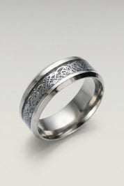 Ring 'Ringshine' in Silber — flacher Stahlring mit Mittelband, in das ein fadenfeiner Drache eingelegt ist, Produktfoto vor hellgrauem Hintergrund