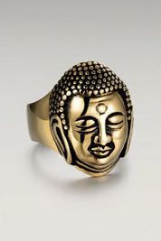 Ring 'Matokoya' in Gold — plastisch gearbeiteter Buddha-Kopf mit fein ausgeformten Locken und markierter Stirn, Produktfoto vor hellgrauem Hintergrund