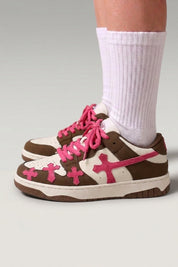 Low-Top-Sneaker 'Shiro' in Rot — geprägte Kreuze an den Seiten, dicke passende Schnürsenkel, am Fuß mit weißen Socken vor grauem Studiohintergrund