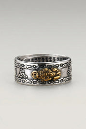 Ring 'Kingu' in Hiragana — Ring mit durchbrochenem Dekor und goldfarbenem Medaillon, Gravur auf der Innenseite, Produktfoto vor hellgrauem Hintergrund