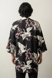 Happi Coat «Tsuru Sakura» mit weißem Kranich und rosa Sakura auf Schwarz, getragene Ansicht der offenen Festival-Jacke