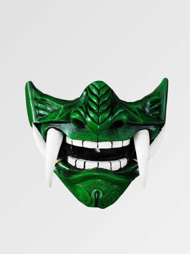 Grüne Mempō-Halbmaske von vorn vor einfarbig grauem Hintergrund — smaragdgrüner Gesichtsschutz mit gravierten Rippen, weißen Zähnen und vorstehenden Eckzähnen