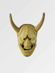 Oni-Maske aus hellem Holz von vorn vor einfarbig grauem Hintergrund — Dämon mit zwei langen geschwungenen Hörnern, langgezogenem Gesicht und leicht offenem Mund