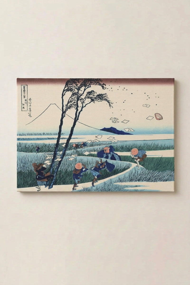 Japanischer Holzschnitt 'Kazega' als Wandbild vor beiger Wand — von einer Bö überraschte Reisende im Feld, davonfliegende Papierblätter, am Horizont der Fuji