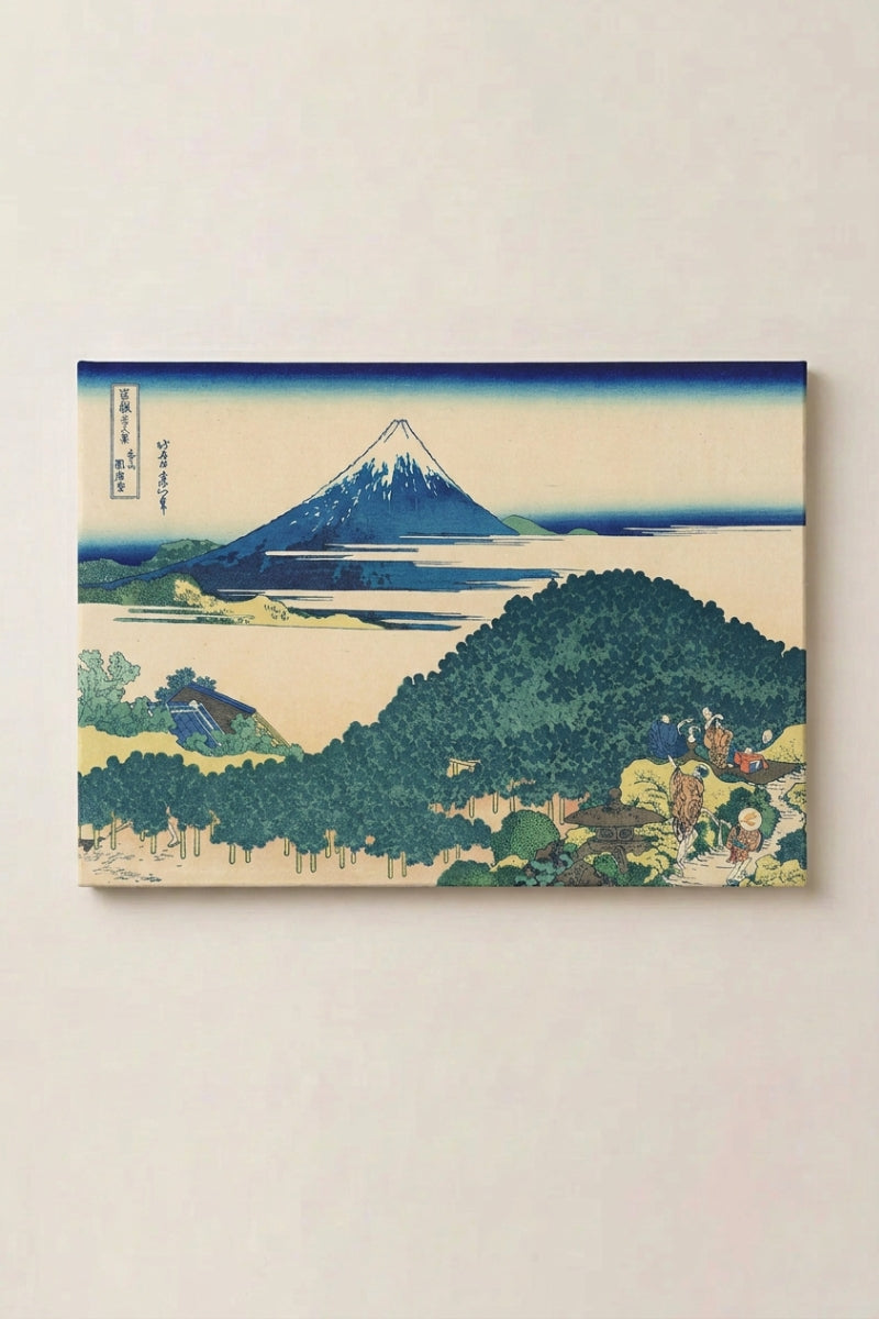 Japanischer Holzschnitt 'Akigo' als gerahmtes Wandbild vor beiger Wand — tiefblauer Fuji, der hinter einem dicht bewaldeten Hügel aufragt, heller Himmel