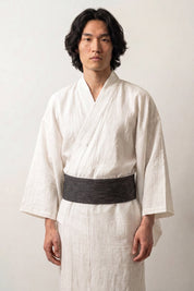 Obi-Gürtel 'Nagoya' über einem weißen Kimono von einem männlichen Model an der Taille getragen — Schwarz mit unregelmäßigen helleren Querlinien