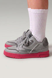 Chunky-Sneaker 'Inazuma' in Rosa — weiß-graues Obermaterial auf kräftig einfarbiger Sohle, am Fuß mit weißen Socken vor grauem Studiohintergrund