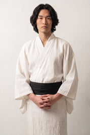 Obi-Gürtel 'Sapporo' über einem weißen Kimono von einem männlichen Model an der Taille getragen — tiefes einfarbiges Schwarz mit dichter, musterfreier Webung