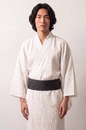 Obi-Gürtel 'Okayama' über einem weißen Kimono von einem männlichen Model an der Taille getragen — sehr dunkles Petrolgrün mit gleichmäßigen hellen Streifen
