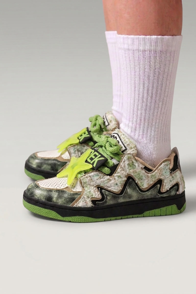 Low-Top-Sneaker 'Kasumi' in Schwarz — durchgehender Graffiti-Print, farblich abgestimmte Sohle, am Fuß mit weißen Socken vor grauem Studiohintergrund