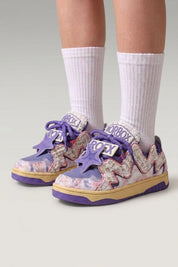 Low-Top-Sneaker 'Kasumi' in Violett — durchgehender Graffiti-Print, farblich abgestimmte Sohle, am Fuß mit weißen Socken vor grauem Studiohintergrund