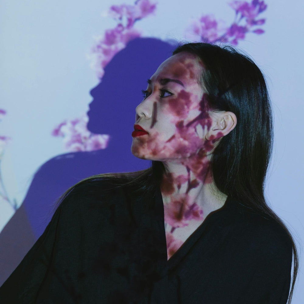 Porträt einer japanischen Frau mit Kirschblütenprojektion im Gesicht, Symbol für die Schönheit und Eleganz der modernen japanischen Mode — Japanische Kleidung