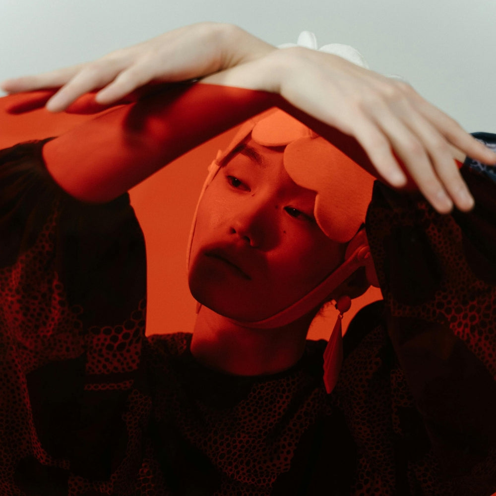 Künstlerisches Porträt eines japanischen Models im roten Licht, das den avantgardistischen Stil und die Kreativität der zeitgenössischen japanischen Mode ausdrückt — Japanische Kleidung