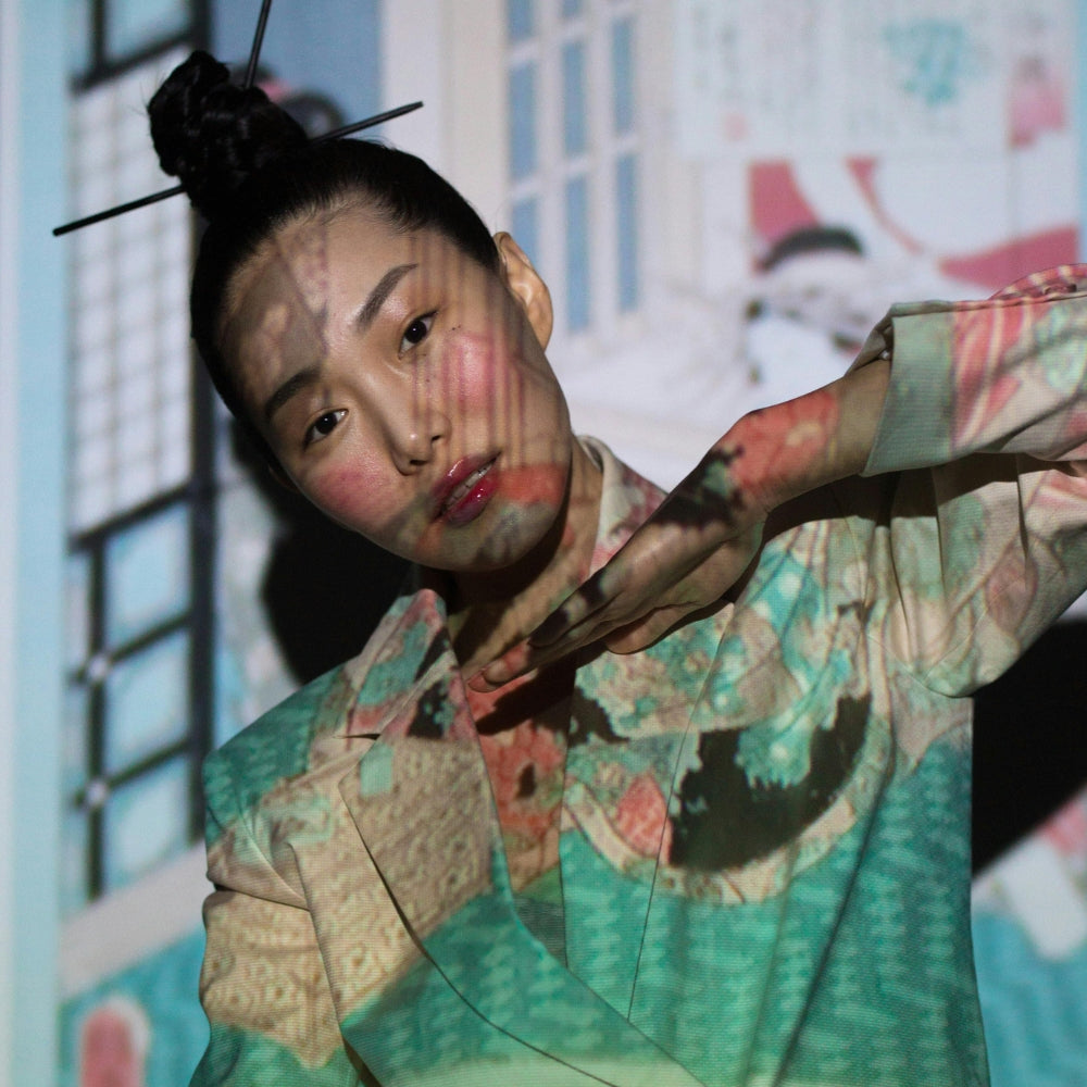 Porträt einer Frau in einer vom japanischen Kimono inspirierten Jacke, beleuchtet durch künstlerische Projektionen – moderne japanische Mode von Japanische Kleidung