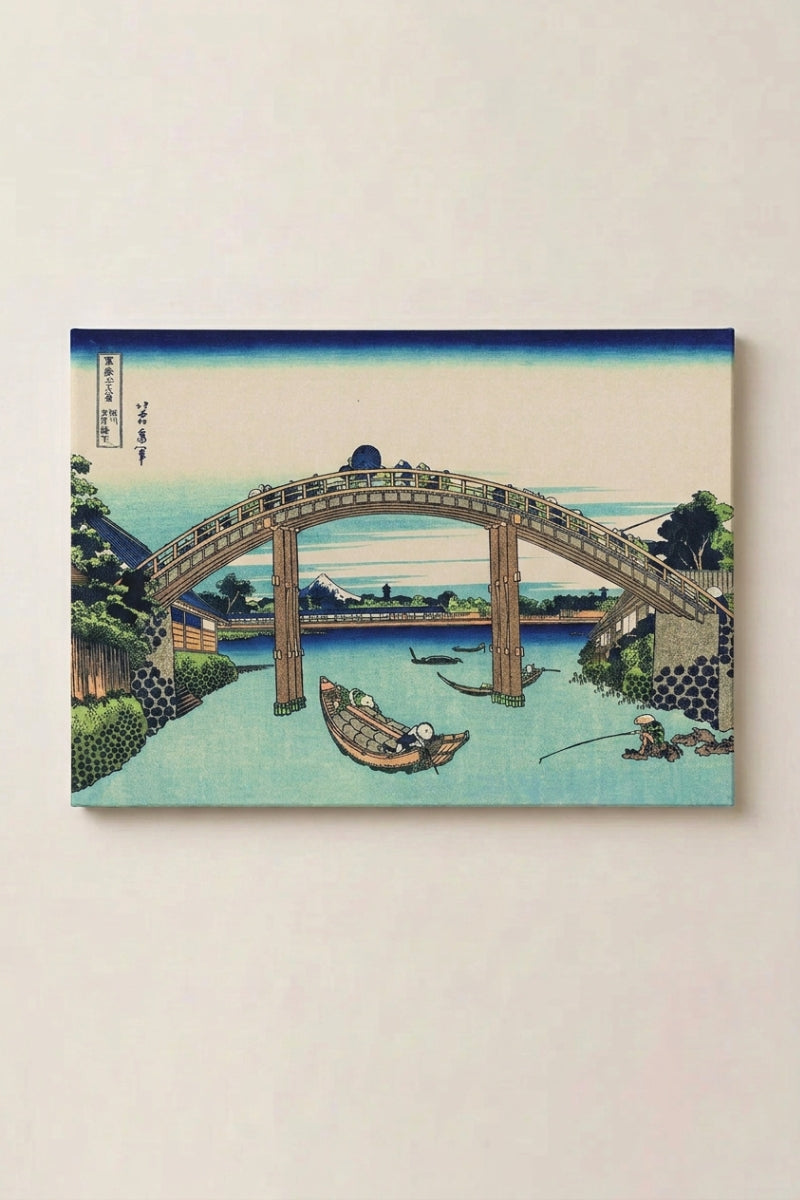 Japanischer Holzschnitt 'Hashi' als gerahmtes Wandbild vor beiger Wand — große hölzerne Bogenbrücke über einen türkisen Fluss mit Booten, dahinter der Fuji